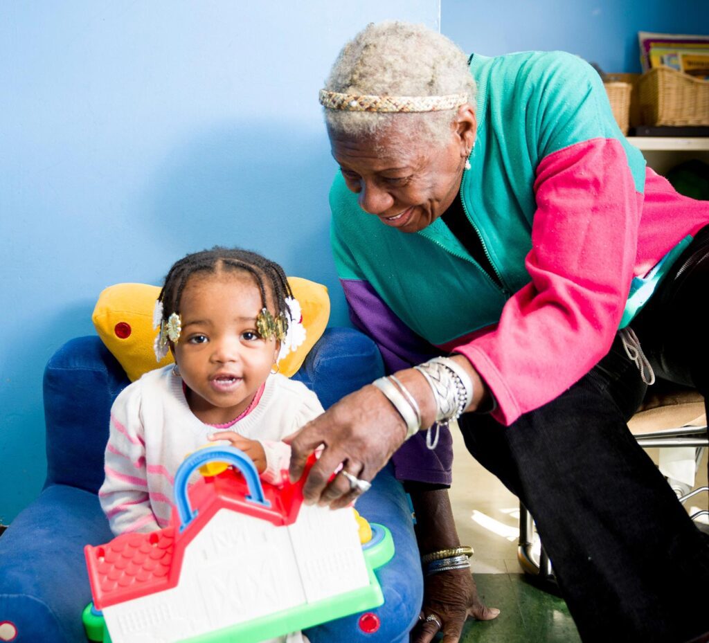 African American grandmother with smiling and playing with granddaughter