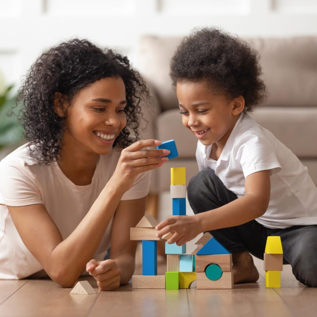 African American mother and child playing with building blocks